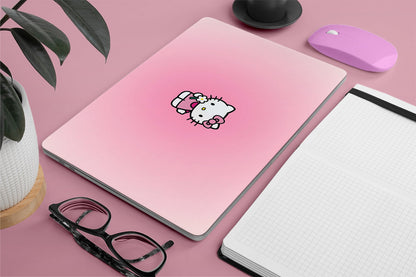 Pink laptop skin with Hello Kitty sticker on a pink surface with a plant, glasses, and mouse.