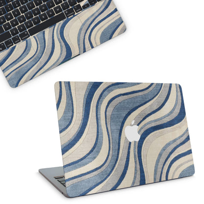 Laptop with a blue and beige wave patterned cover on a white background